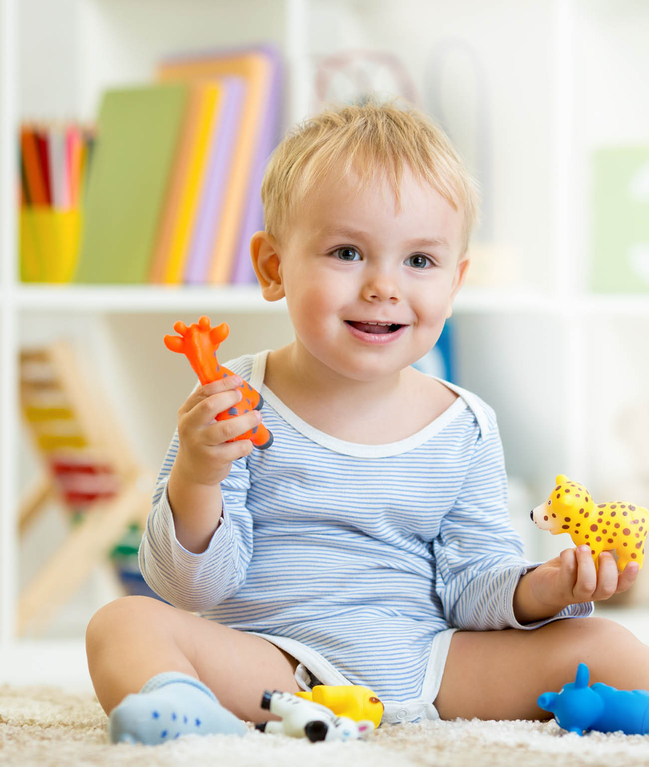 smart child boy plays animal toys sitting on floor