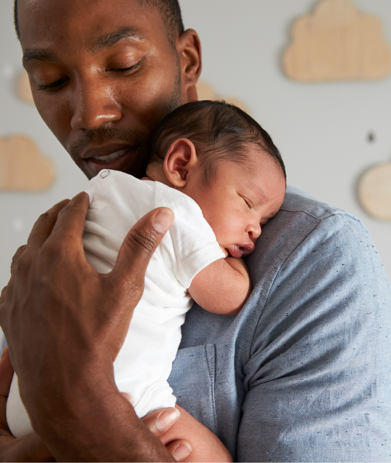 Father Holding Newborn Baby Son In Nursery