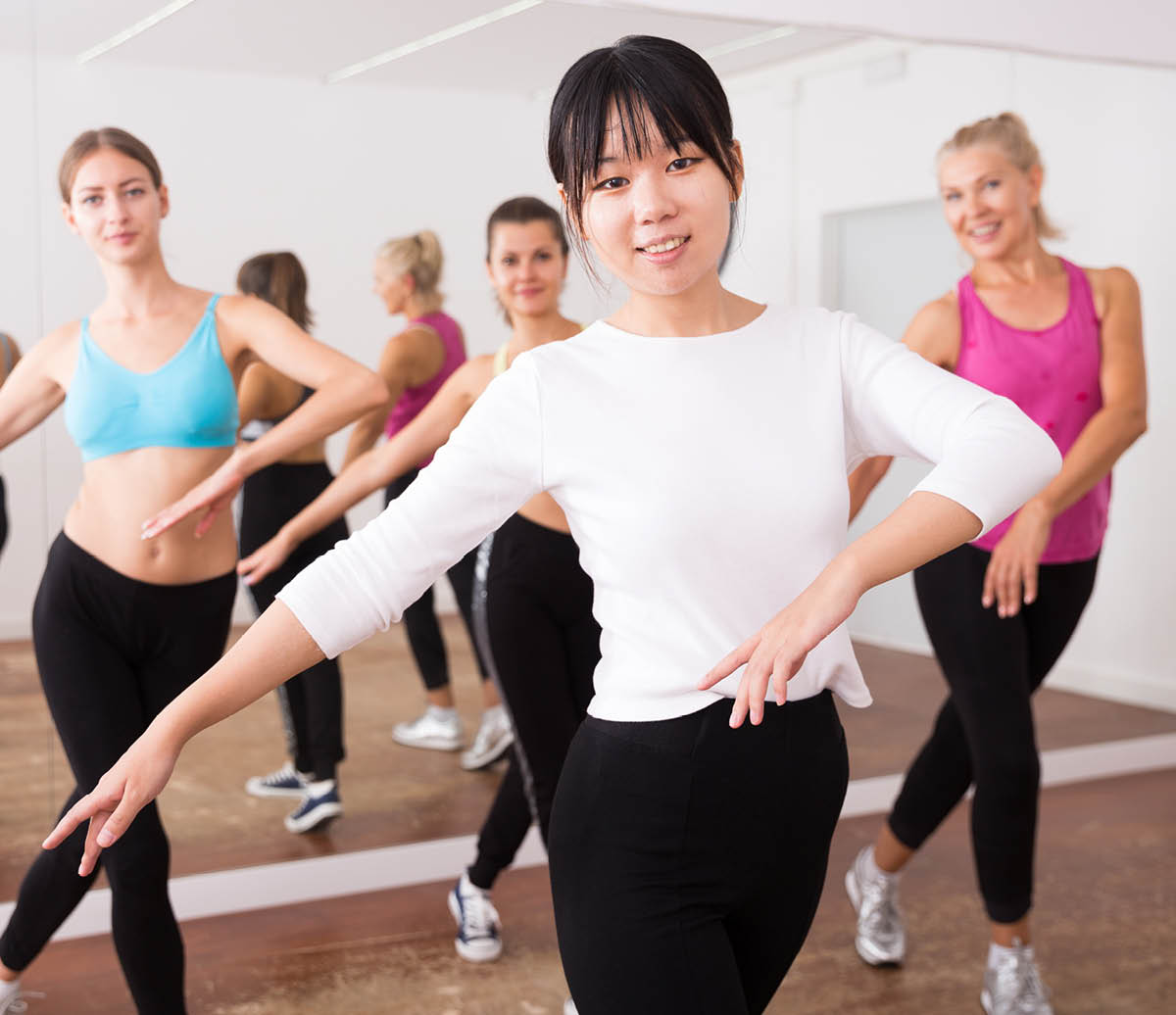 Girl of chinese appearance dances in a group of dancers